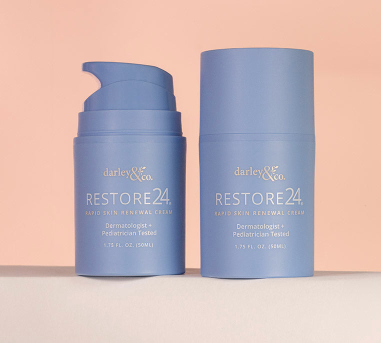 Two RESTORE24 bottles from darley & co. on a peach background