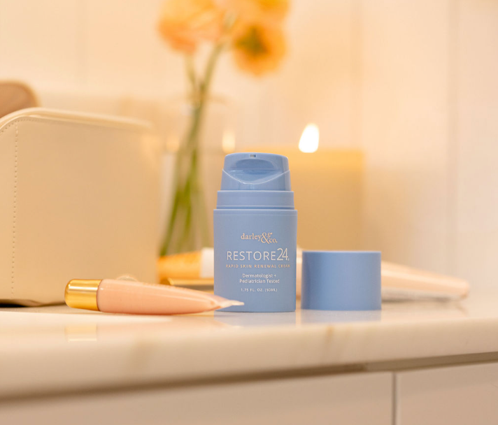 Blue RESTORE24 bottle with applicator on a bathroom counter with a soft focus background